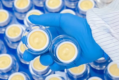 Hand holding cream jars